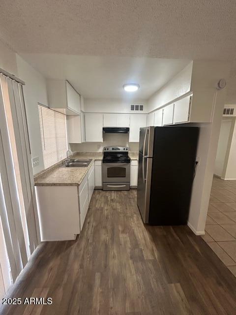 4625 W Thomas Rd Unit 48, Phoenix, AZ 85031 - kitchen with stainless steel appliances, ventilation hood, dark wood-style floors, light countertops, and a textured ceiling