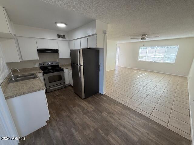 4625 W Thomas Rd Unit 48, Phoenix, AZ 85031 - kitchen featuring appliances with stainless steel finishes, ventilation hood, ceiling fan, light countertops, and a textured ceiling