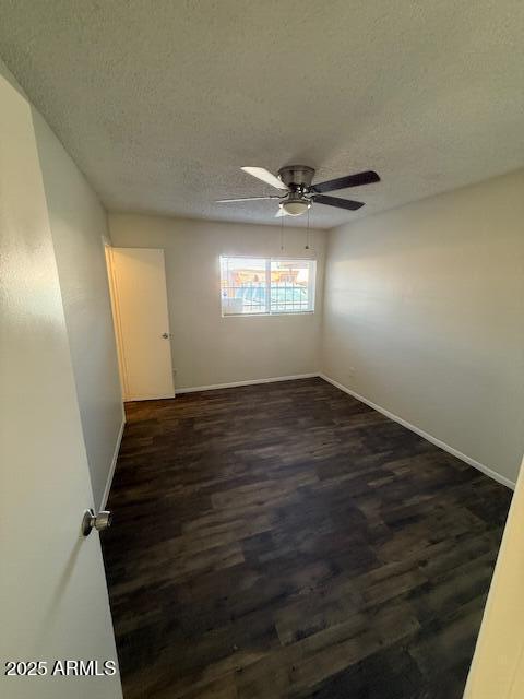 4625 W Thomas Rd Unit 48, Phoenix, AZ 85031 - unfurnished room with dark wood-style flooring, a textured ceiling, and a ceiling fan