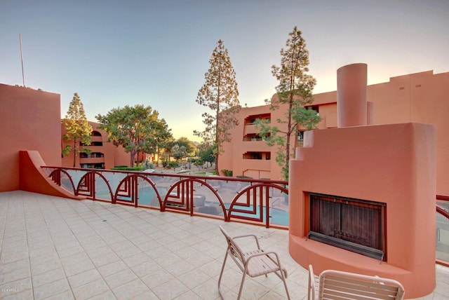 patio terrace at dusk featuring a balcony