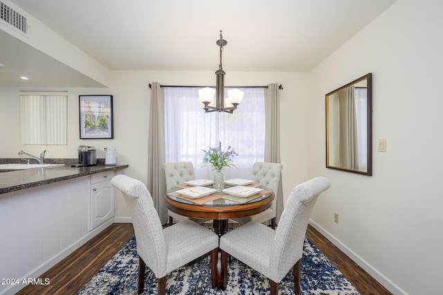 dining space featuring a chandelier, sink, and dark hardwood / wood-style flooring