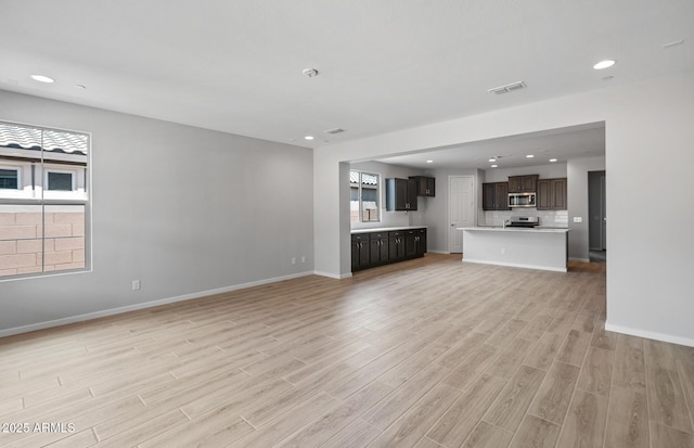 13512 W Copperleaf Ln, Peoria, AZ 85383 - unfurnished living room with light wood-style flooring and recessed lighting