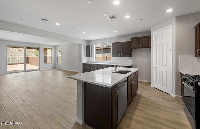 13512 W Copperleaf Ln, Peoria, AZ 85383 - kitchen featuring range with gas stovetop, stainless steel dishwasher, backsplash, a center island with sink, and recessed lighting