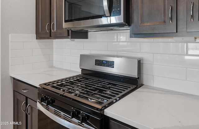 13512 W Copperleaf Ln, Peoria, AZ 85383 - kitchen with stainless steel appliances, dark brown cabinets, backsplash, and light stone countertops