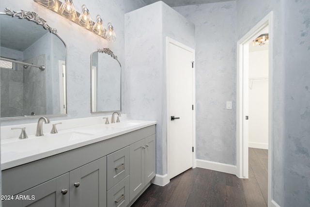 bathroom featuring a tile shower, vanity, and hardwood / wood-style flooring