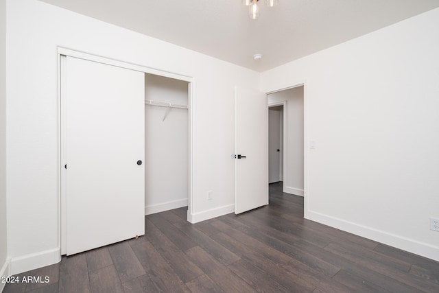 unfurnished bedroom with a closet and dark wood-type flooring