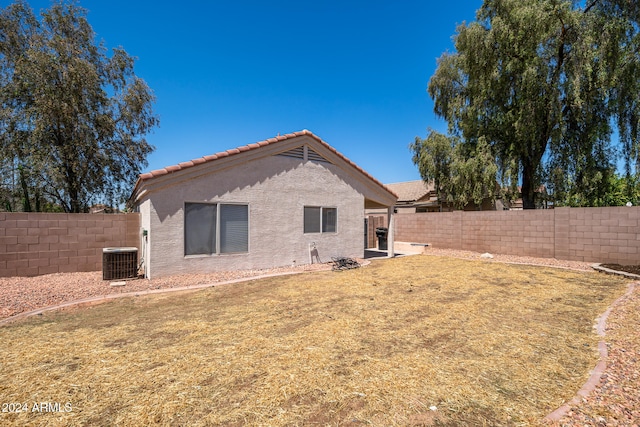 rear view of house with a lawn and central air condition unit