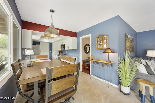 dining space featuring baseboards and concrete floors