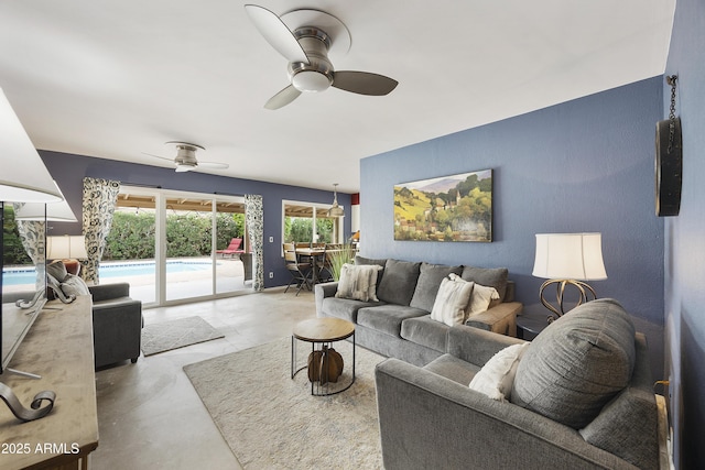 living area with baseboards, concrete floors, and ceiling fan