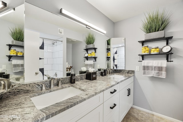 bathroom featuring double vanity, visible vents, tiled shower, and a sink