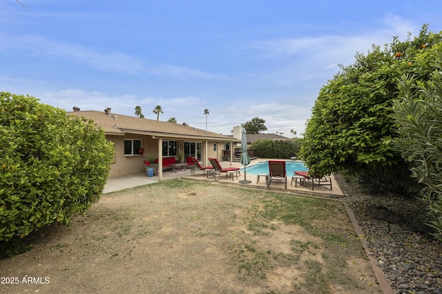 rear view of property with an outdoor pool and a patio area