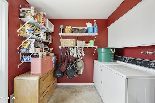 washroom featuring washer and clothes dryer and cabinet space