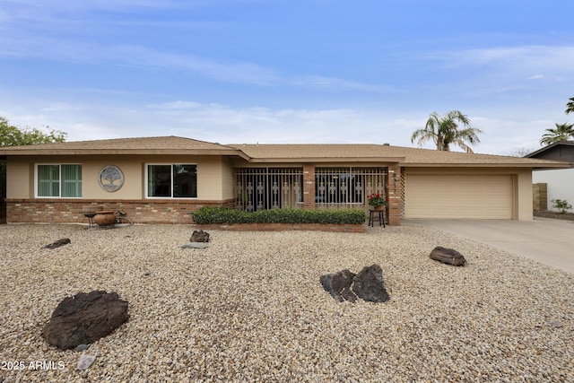 ranch-style house with brick siding, concrete driveway, a garage, and a shingled roof