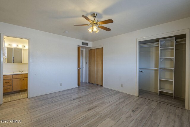 5657 E Dallas St, Mesa, AZ 85205 - unfurnished bedroom featuring light wood-type flooring, two closets, connected bathroom, a ceiling fan, and baseboards