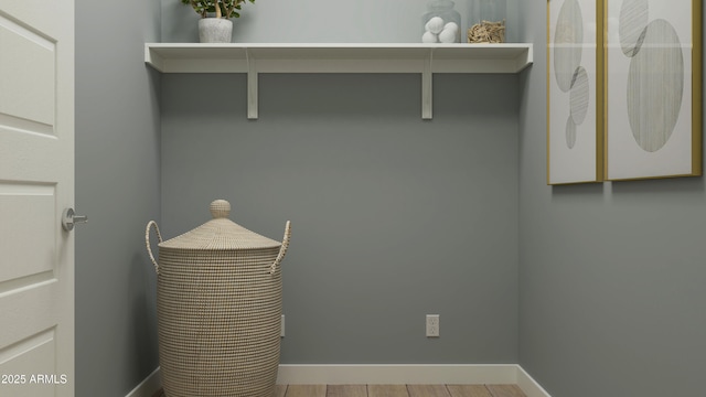 laundry room featuring baseboards and wood finished floors
