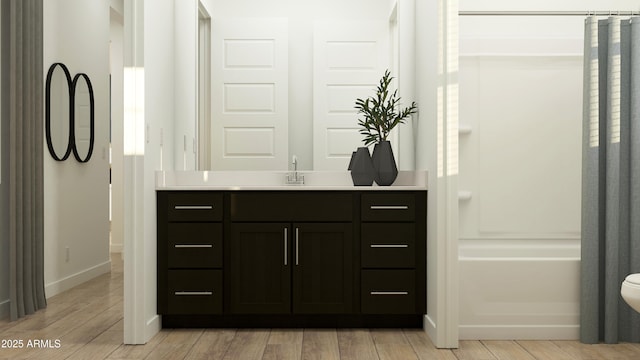 bathroom featuring vanity, baseboards, and wood finished floors