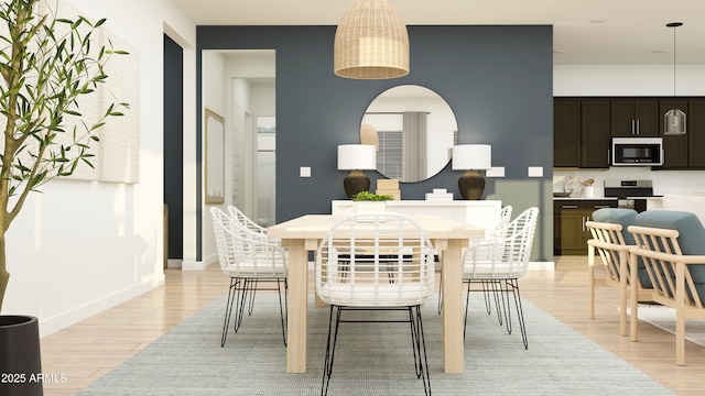 dining area with arched walkways, baseboards, and light wood finished floors