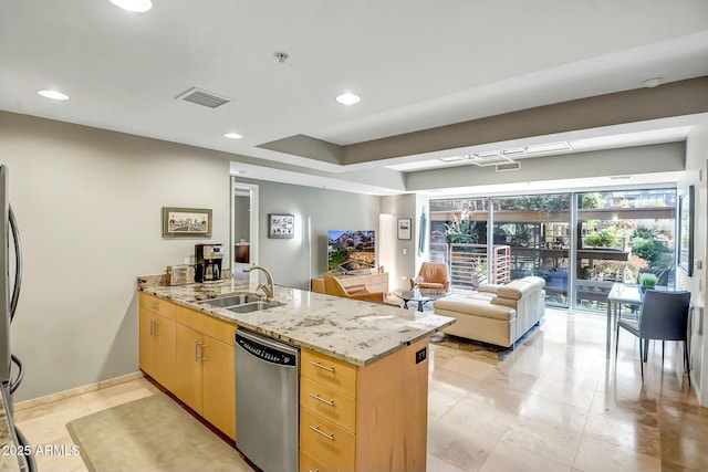 kitchen with sink, stainless steel appliances, light stone countertops, kitchen peninsula, and light brown cabinets