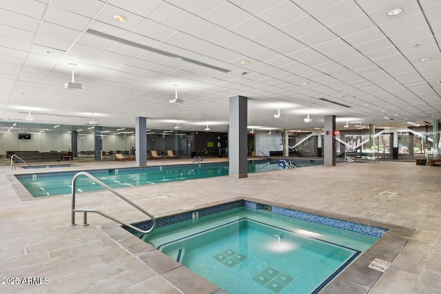 view of swimming pool with an indoor in ground hot tub and a patio area