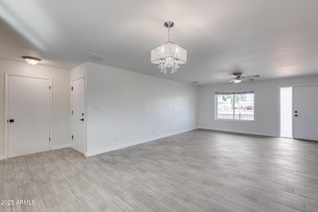 unfurnished room with ceiling fan with notable chandelier