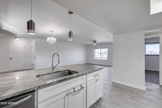 kitchen with sink, white cabinetry, ceiling fan, stainless steel dishwasher, and pendant lighting