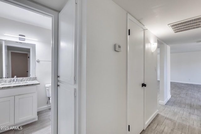 hall featuring light hardwood / wood-style flooring and sink