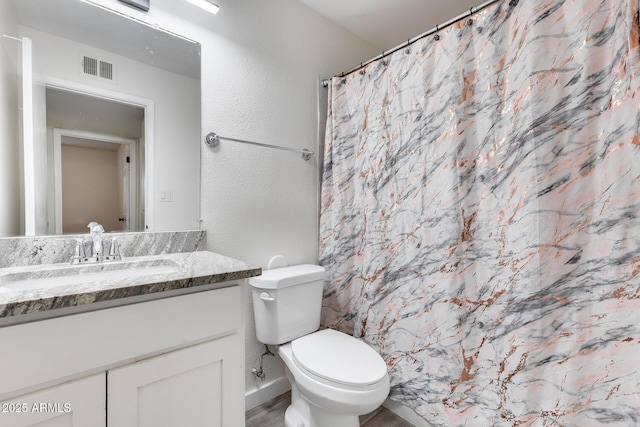 bathroom featuring toilet, a shower with curtain, and vanity