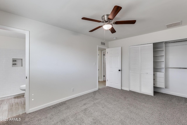 unfurnished bedroom with ensuite bathroom, ceiling fan, a closet, and carpet