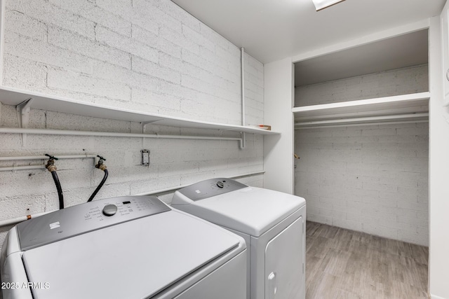 clothes washing area with light wood-type flooring and washing machine and dryer