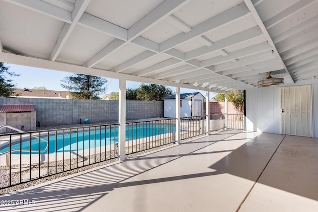 view of pool featuring a patio and a storage unit