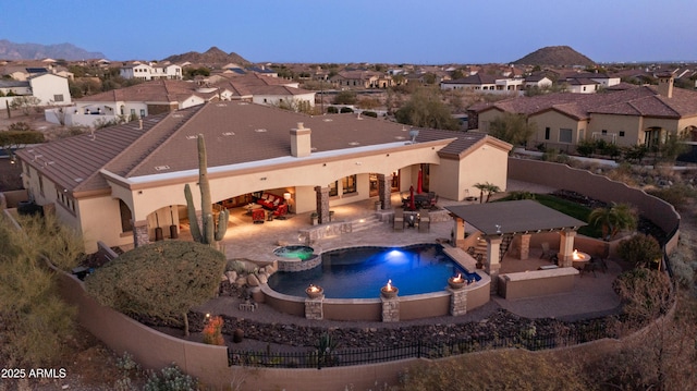 exterior space featuring an in ground hot tub, a gazebo, exterior bar, and a patio