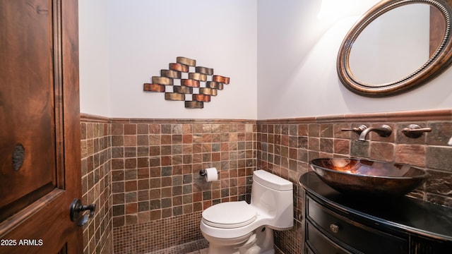 bathroom featuring vanity, tile walls, and toilet