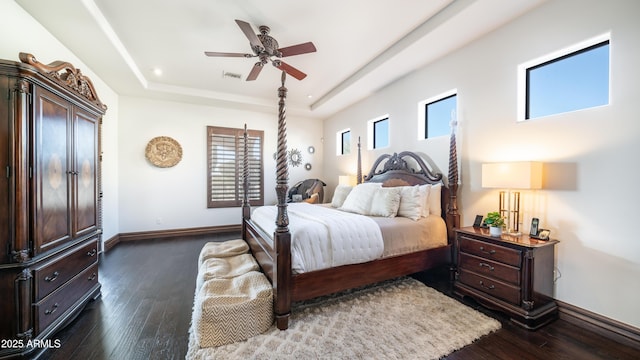 bedroom featuring ceiling fan, dark hardwood / wood-style floors, and a raised ceiling