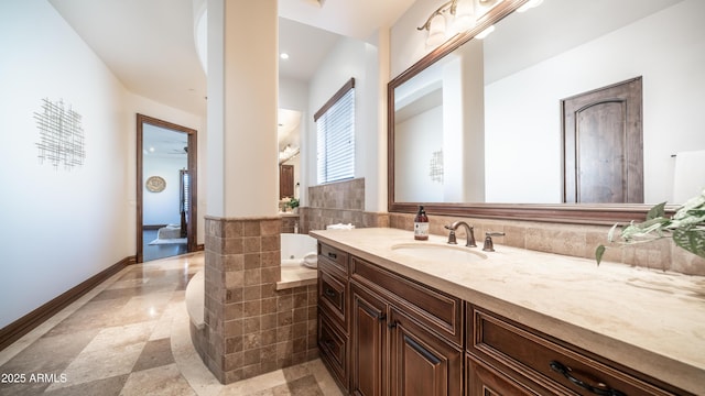 bathroom with vanity and tiled tub