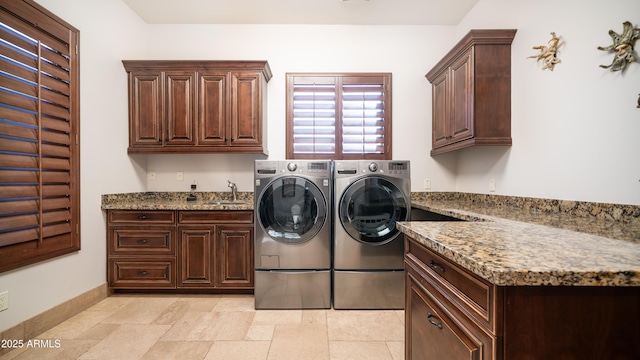 laundry area featuring washer and dryer, sink, and cabinets