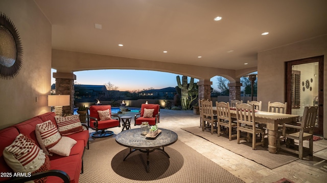 patio terrace at dusk with outdoor lounge area and a fenced in pool