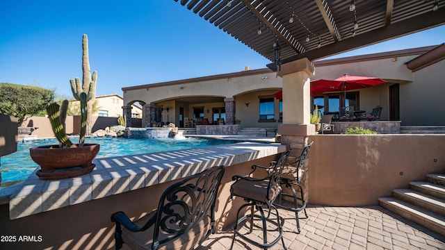 view of swimming pool with a patio area, an outdoor bar, and pool water feature