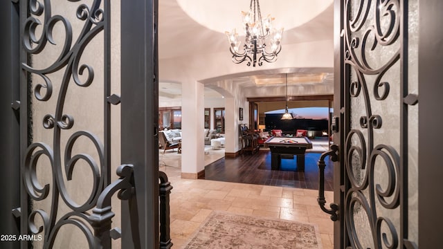 foyer entrance with pool table and a notable chandelier