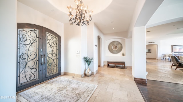 entrance foyer featuring a notable chandelier and french doors