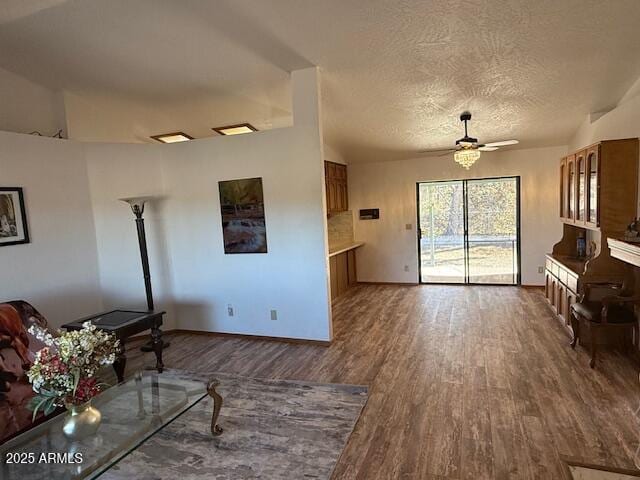 living room featuring ceiling fan, dark hardwood / wood-style floors, and a textured ceiling