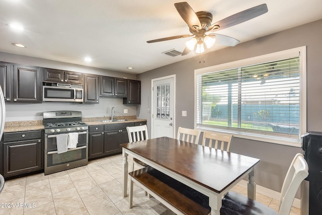 kitchen with ceiling fan, stainless steel appliances, sink, and dark brown cabinets