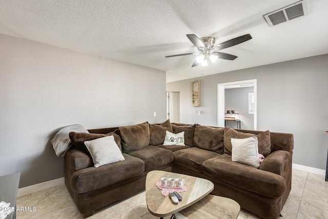 living room featuring ceiling fan and a textured ceiling