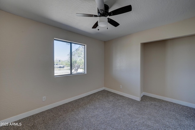 spare room featuring carpet floors, a textured ceiling, baseboards, and ceiling fan