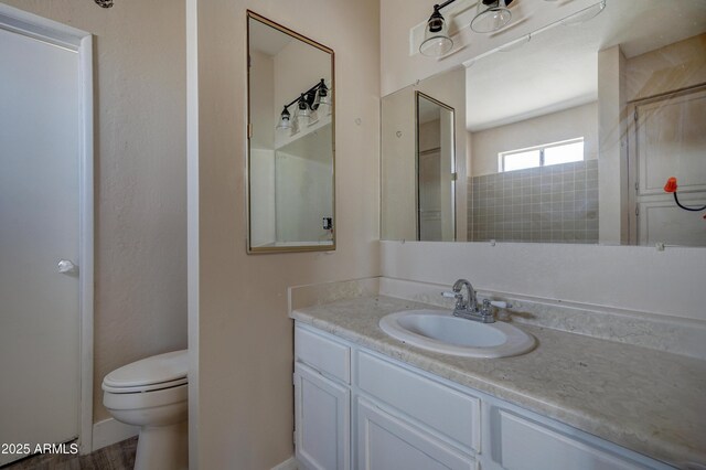 bathroom with toilet, vanity, and baseboards