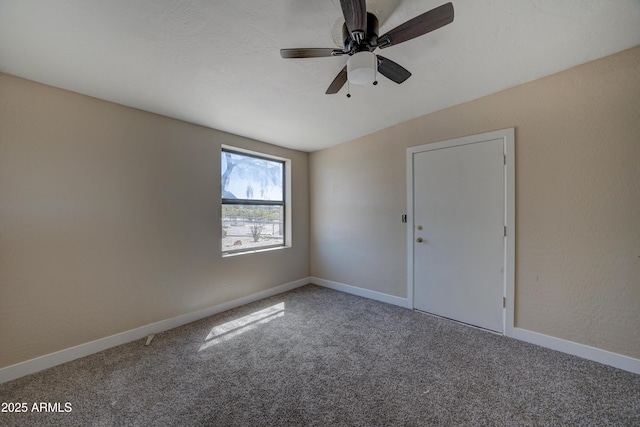 spare room featuring carpet floors, baseboards, and ceiling fan