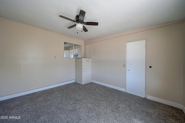 unfurnished room with carpet floors, a ceiling fan, and baseboards