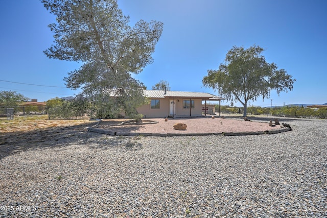 back of house with metal roof