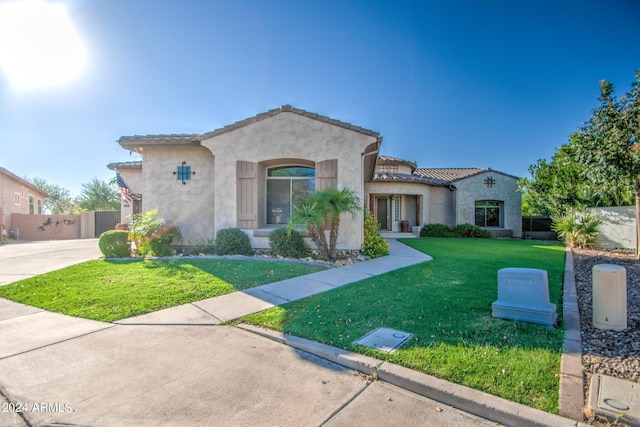 mediterranean / spanish home featuring a front lawn