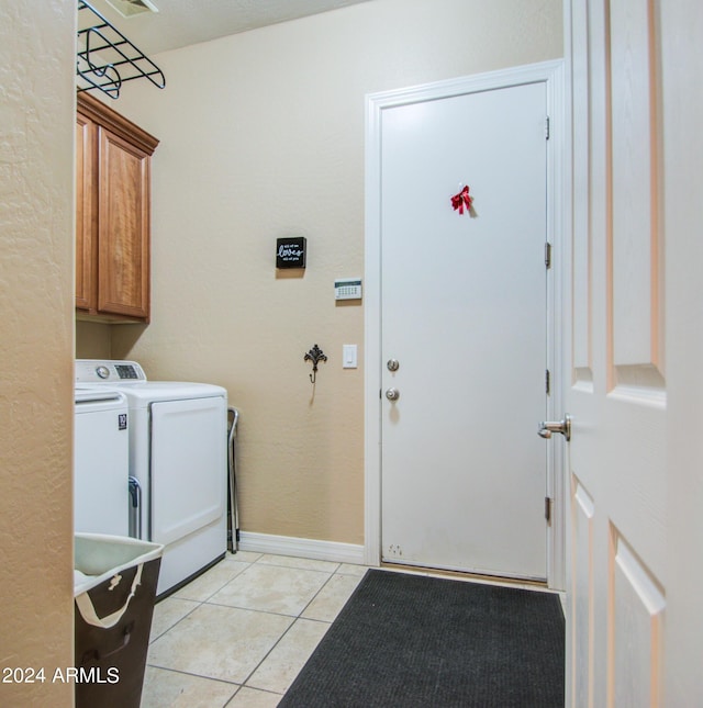 laundry area featuring cabinets, independent washer and dryer, and light tile patterned flooring