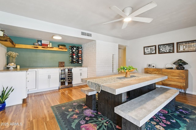 13842 N 40th Ave, Phoenix, AZ 85053 - dining space featuring beverage cooler, bar, light wood finished floors, and a ceiling fan